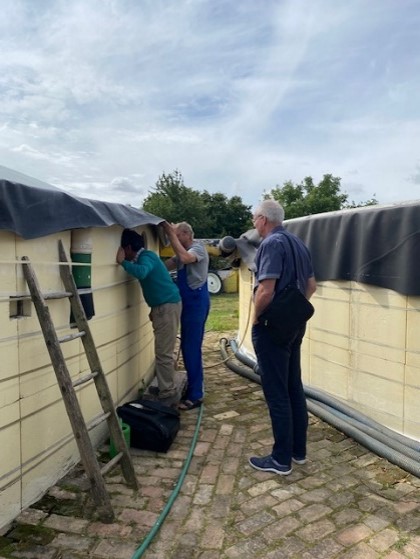 The farmer and advisor looking at how the biogas digester is working and how the content is mixing and separating from each other.