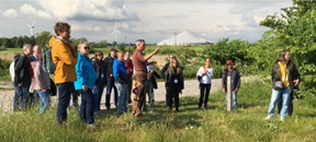 Advisor showing farmers where the experiment will be done,explaining some features of the area and its significance to the project.